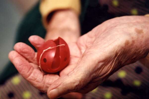 old hand with plastic red nose on palm
